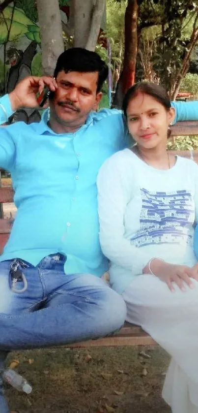 Couple relaxing on park bench amidst nature.