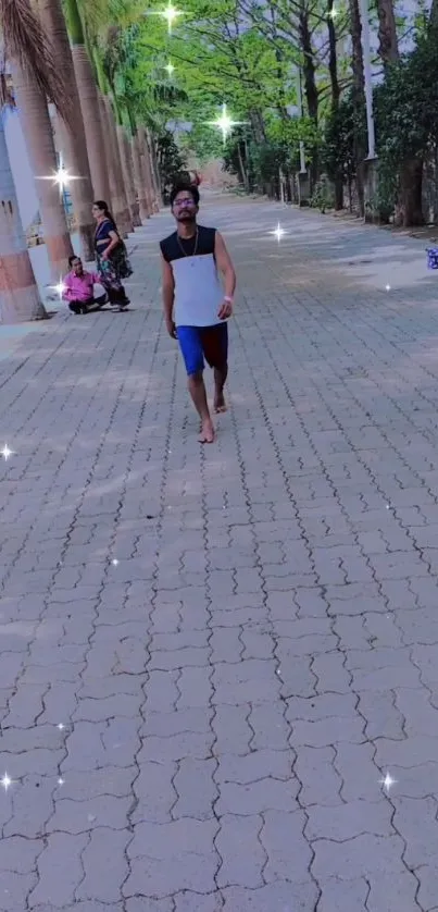 Man walking in a tree-lined park pathway with sparkles.