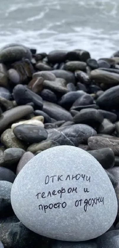 Pebble beach with message on stone against ocean backdrop, serene and calming.