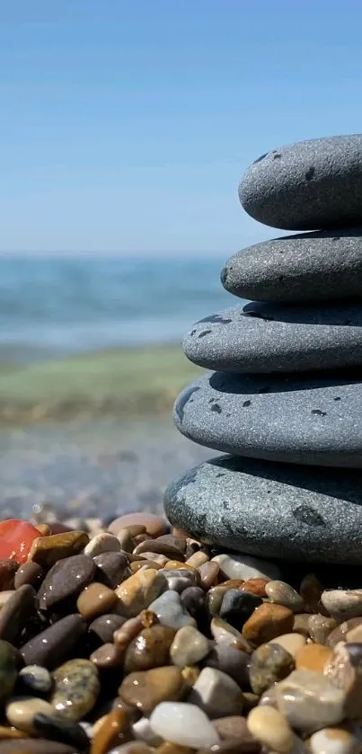 Pebbles stacked on a tranquil beach by the ocean.