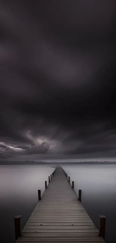 Dramatic sky above serene pier stretching into calm water.