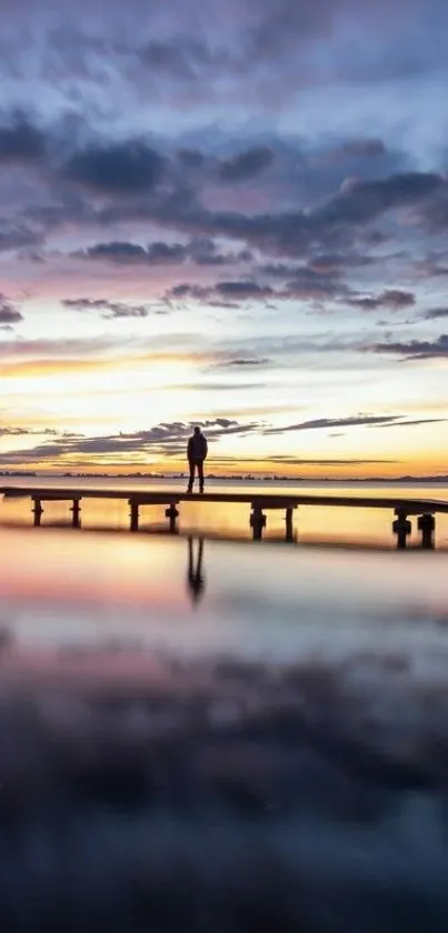 Serene pier at sunset with vibrant sky and reflections.