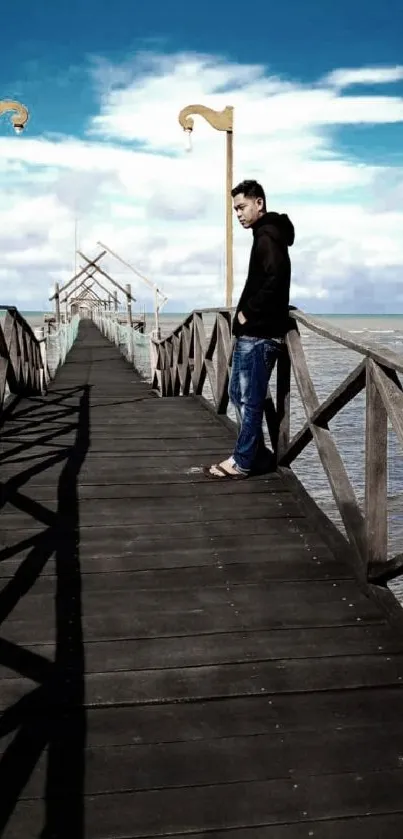 Man standing on wooden pier over blue sea and sky.