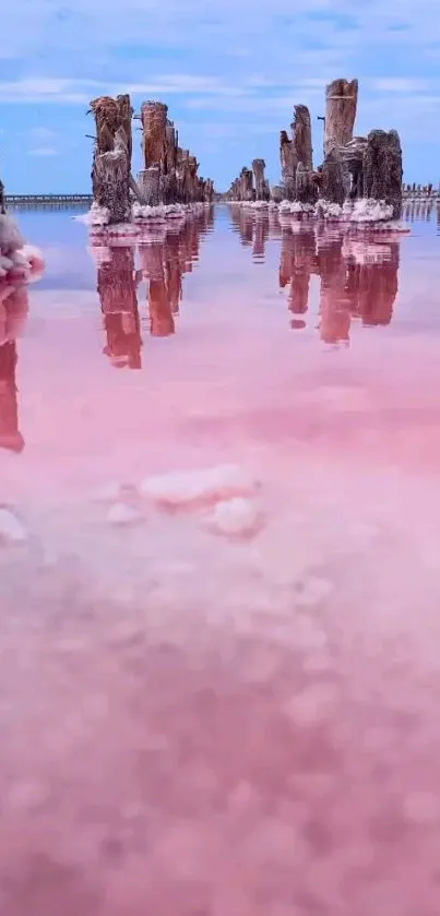 Serene pink lake with wooden structures reflecting a blue sky.