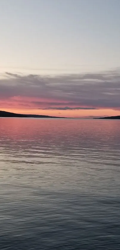 Tranquil pink sunset over calm waters for mobile wallpaper.