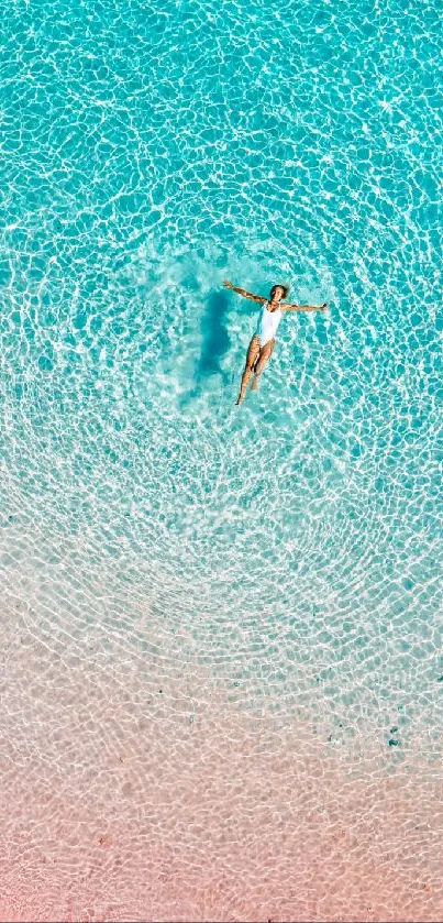 Aerial view of a person floating in a serene, clear blue pool.