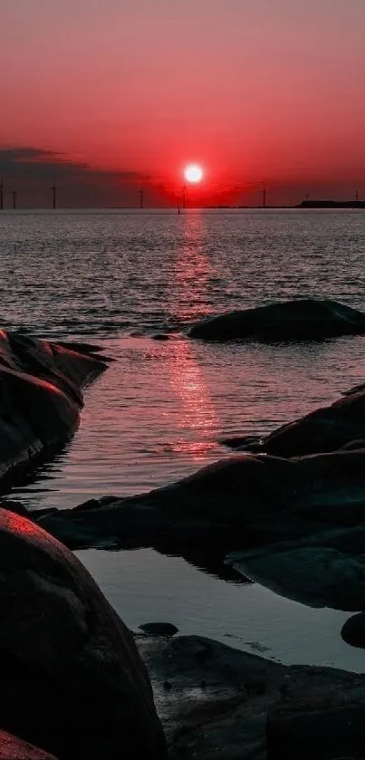 Beautiful red sunset over sea with rocky foreground.