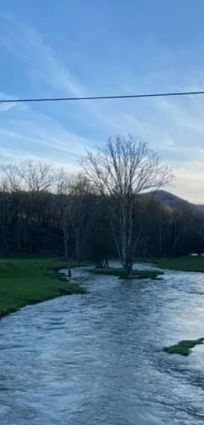 Peaceful river landscape with blue sky and lush greenery.