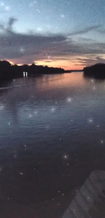 Serene sunset over a calm river with a dark blue sky reflecting on the water.