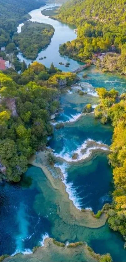 Aerial view of a lush green river valley with cascading waterfalls.