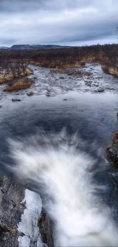 Serene winter river landscape with flowing water and cloudy sky.