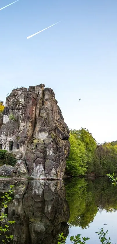 Rock formations reflecting in a tranquil lake under a clear blue sky.