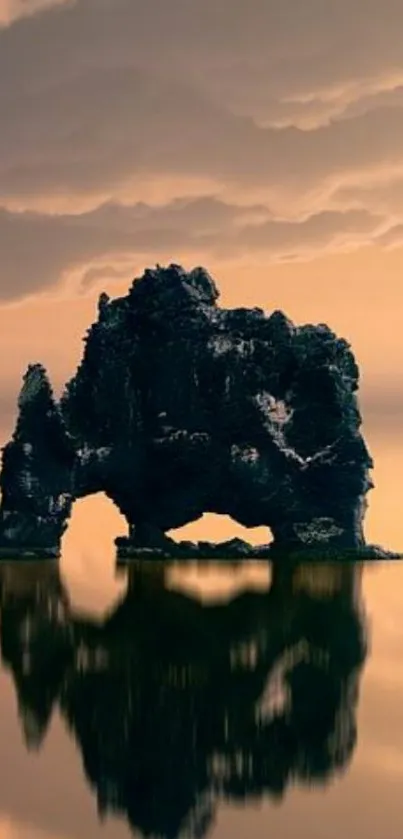 Serene rock formation reflecting in calm waters under a cloudy sky.