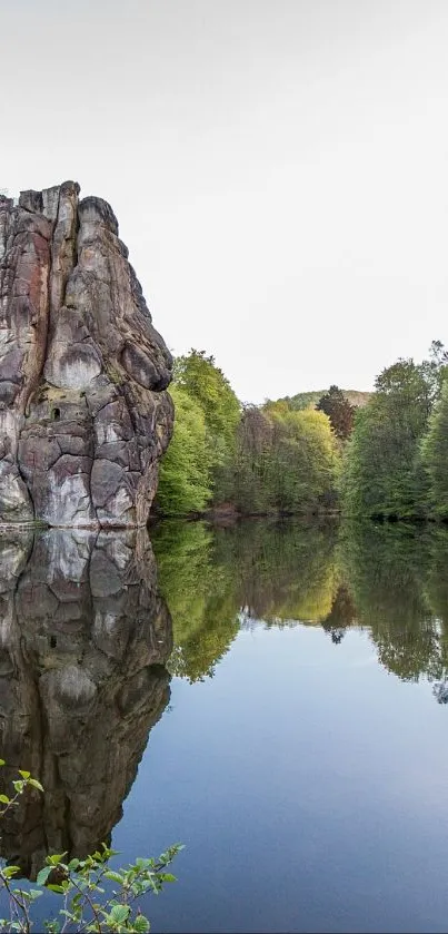 Rock formations reflected in calm water with surrounding greenery.