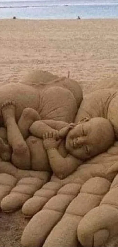 Sand sculpture of hands cradling a baby on serene beach.