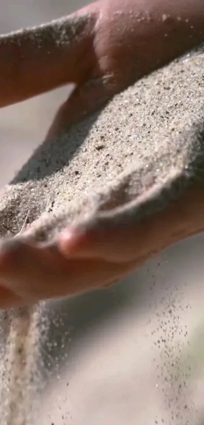 Close-up of a hand with sand flowing gently through fingers.