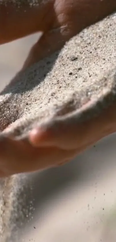 Hand gently letting sand flow, capturing serene and natural beauty.