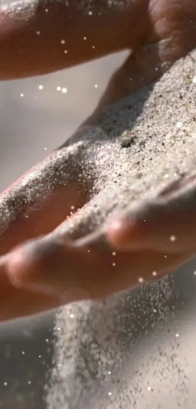 Elegant wallpaper of sand flowing through a hand, evoking serenity.