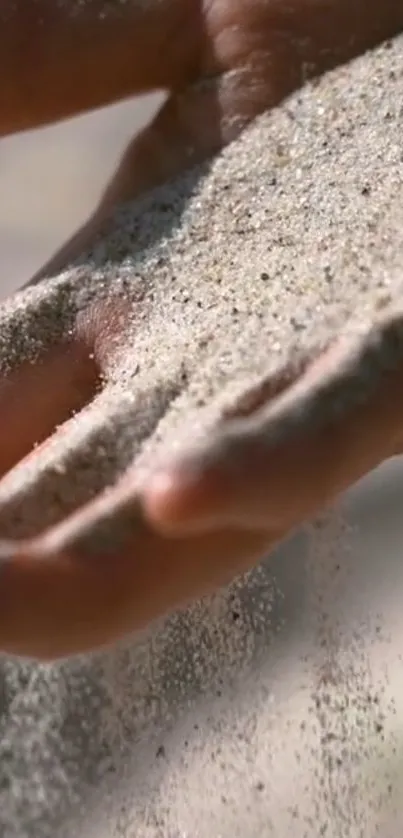 Flowing sand through fingers on a hand with a serene background.