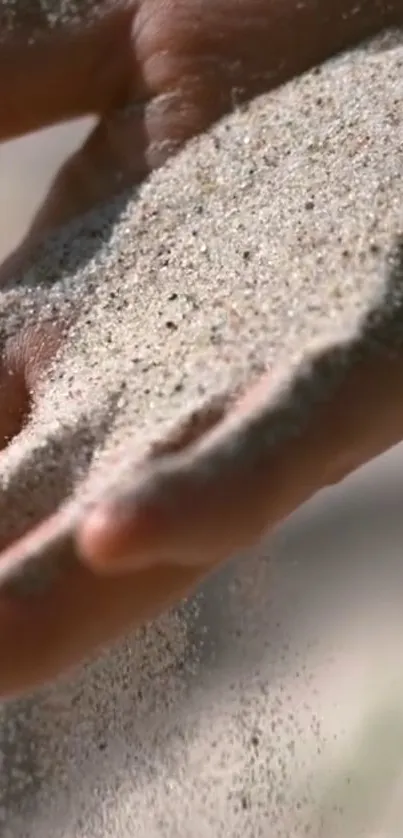 A gentle hand holding fine sand, creating a tranquil and serene visual.