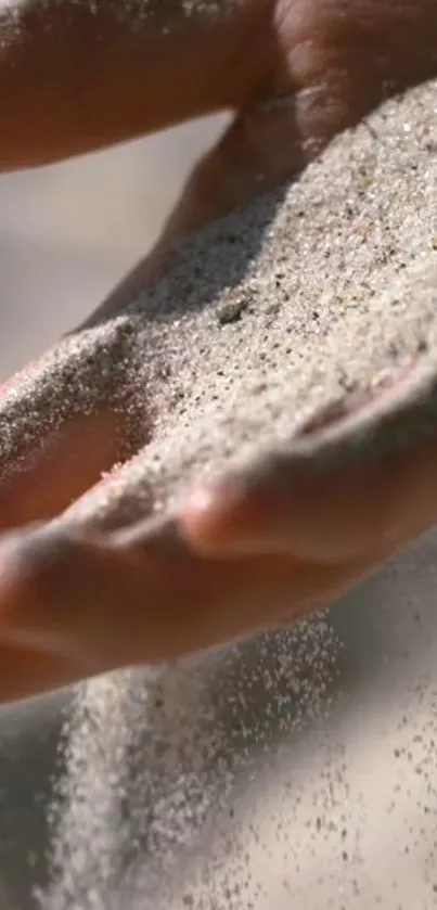 Close-up of sand flowing smoothly through a hand, capturing tranquility.