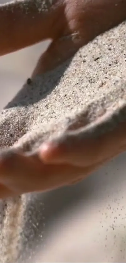 Close-up of sand flowing gently through a person's hand.