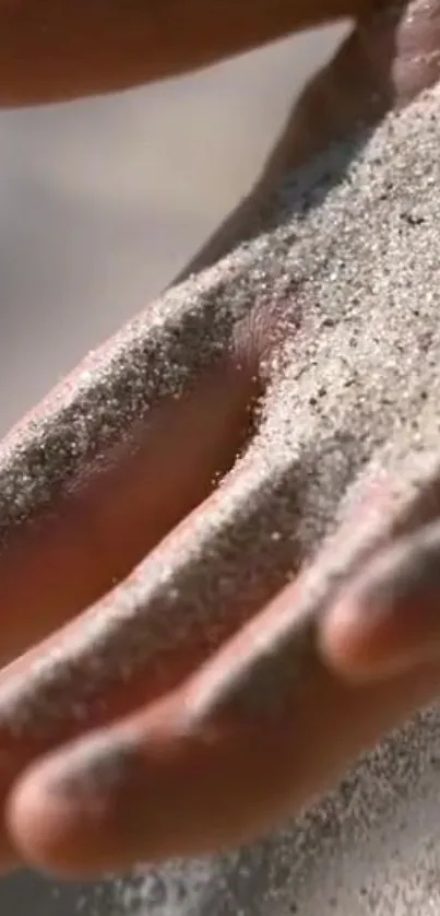 Close-up of sand resting on hands in mobile wallpaper.