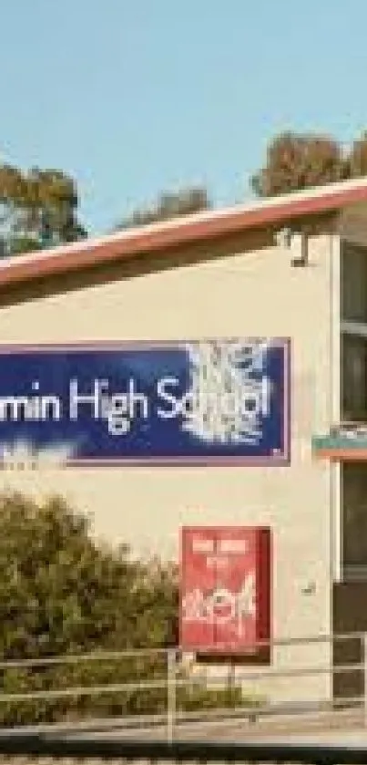 High school building with a sign and trees against a clear sky.