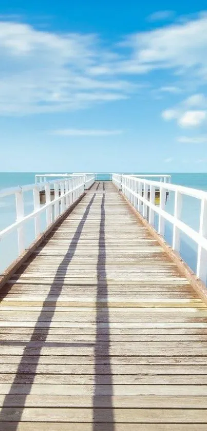 Serene wooden pier leading to the ocean under clear blue skies.