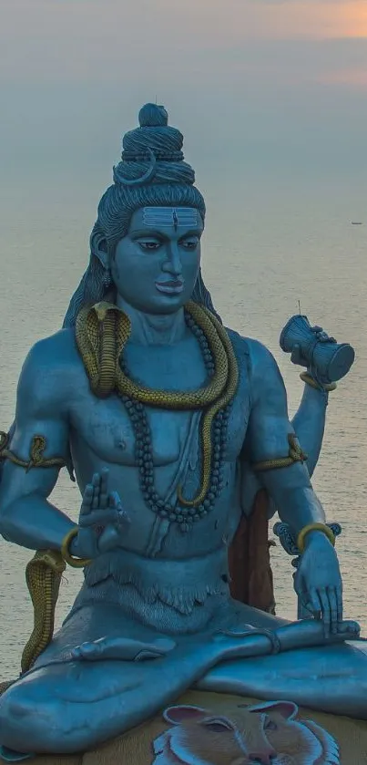 Majestic Shiva statue overlooking the ocean at sunset.