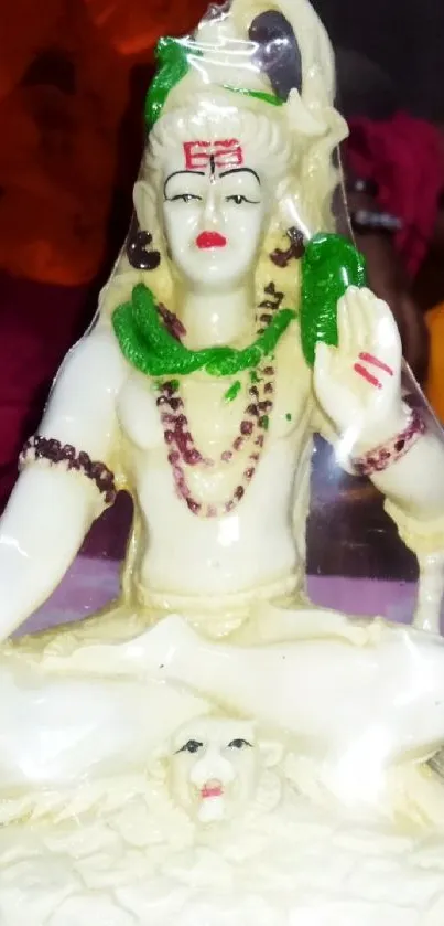 Cream colored Shiva figurine with vivid accents on a decorative background.