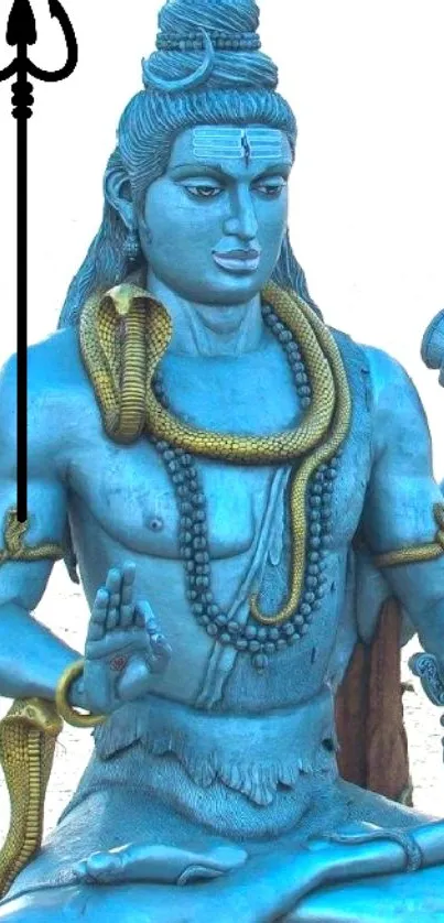 Statue of Shiva with a serene expression, adorned with snakes and trident on blue background.