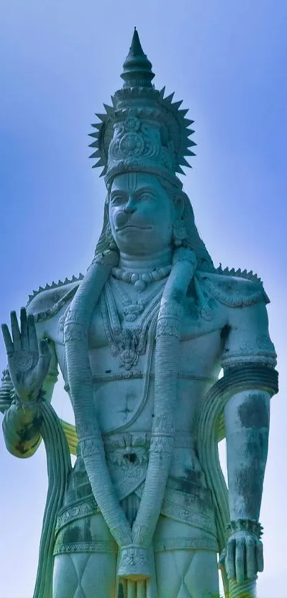 Shiva statue against a serene blue sky in mobile wallpaper.