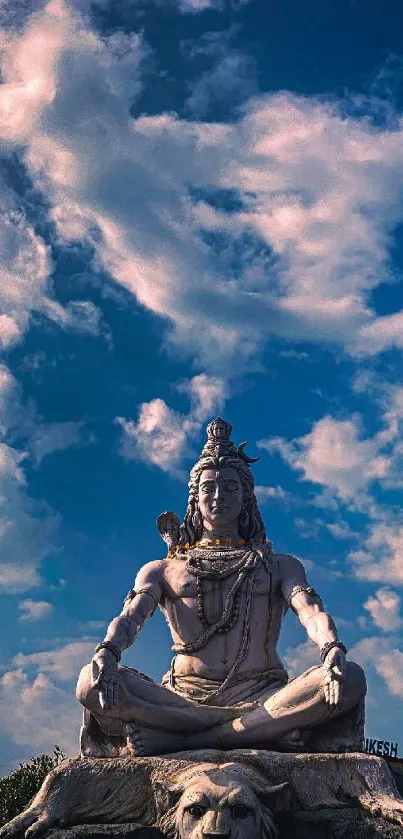 Shiva statue under a vibrant blue sky.