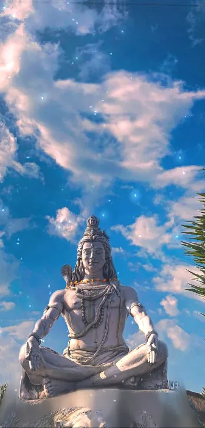 Shiva statue meditating under a vibrant blue sky with clouds.