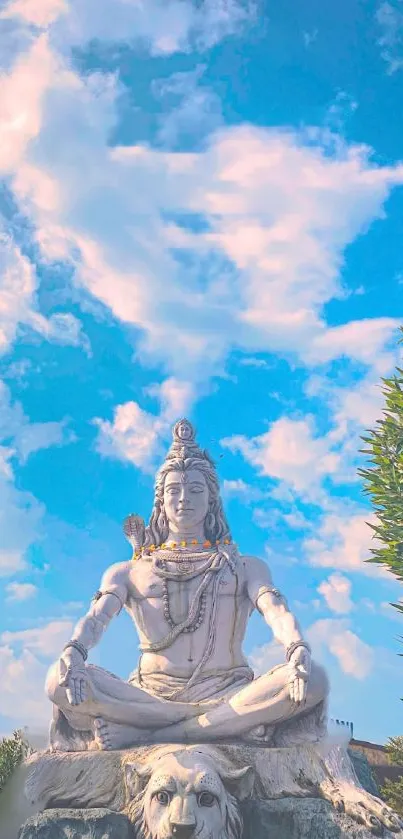 Lord Shiva statue against a bright blue sky, perfect for mobile wallpaper.