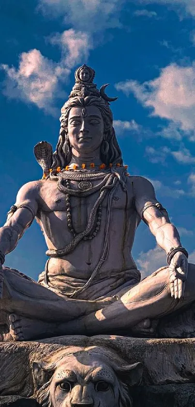 Shiva statue with blue sky and clouds in mobile wallpaper.