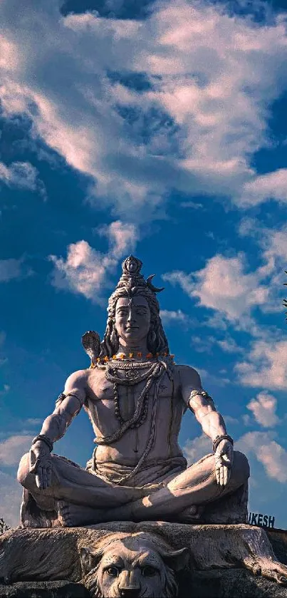 Serene Lord Shiva statue with blue sky and clouds.