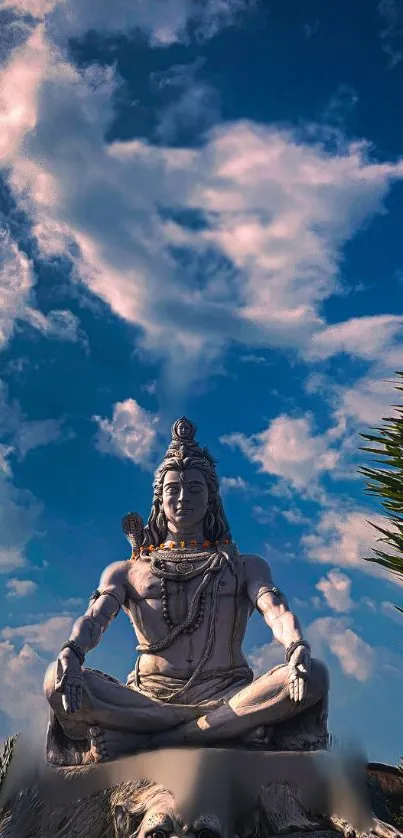 Shiva statue under blue sky, exuding tranquility and spiritual calm.