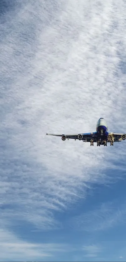 Airplane soaring in a blue sky with wispy clouds.