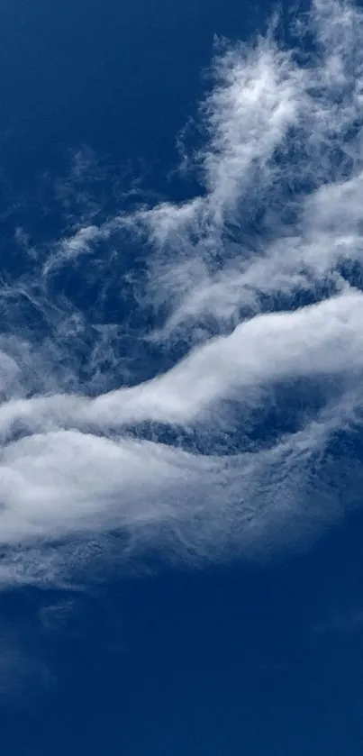 Serene blue sky with wispy white clouds.