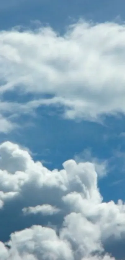 Serene sky with fluffy white clouds against blue background.