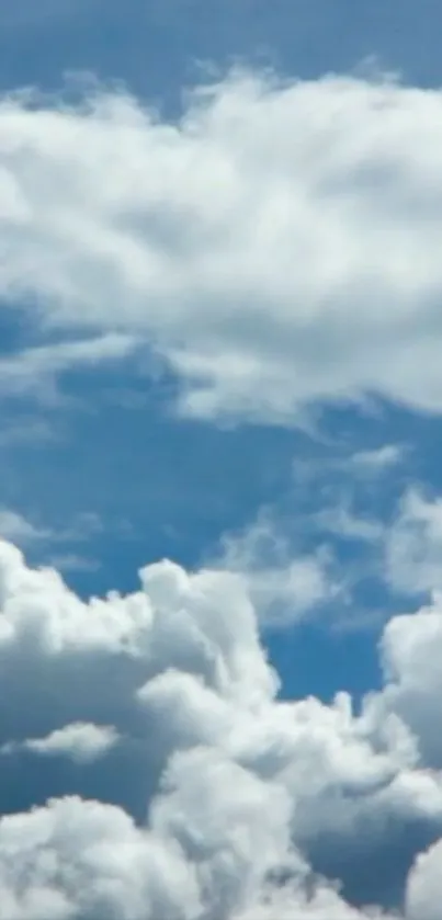 Serene blue sky with fluffy white clouds wallpaper.