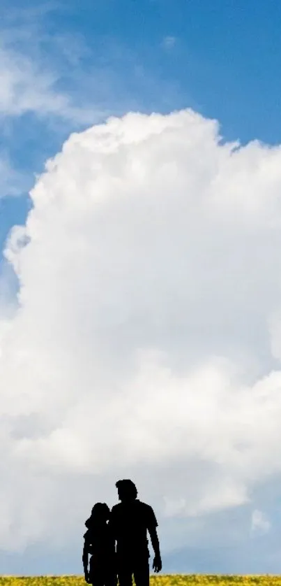 Silhouette of couple against vibrant blue sky with fluffy clouds.