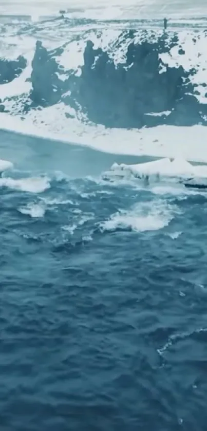 Snowy coastline with dark blue ocean waves.