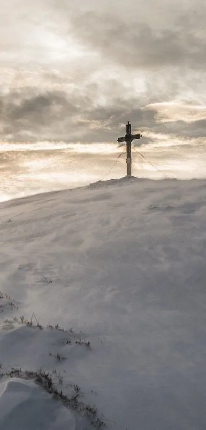 A cross on a snowy hill under a cloudy sky serves as a serene mobile wallpaper.