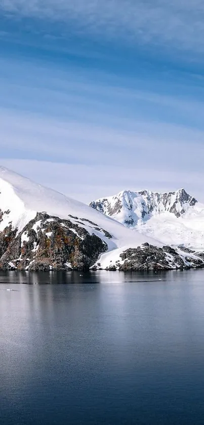 Serene snowy mountain reflected in calm blue waters.