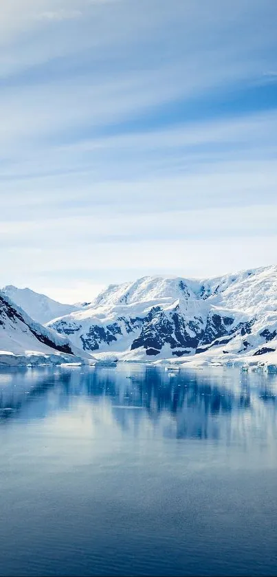 Snowy mountain reflecting in blue water under a clear sky.