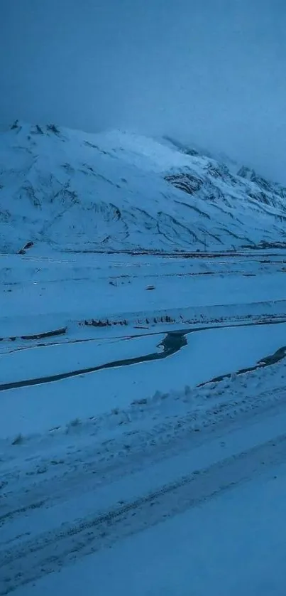 A serene snow-covered mountain lit by icy blue twilight.