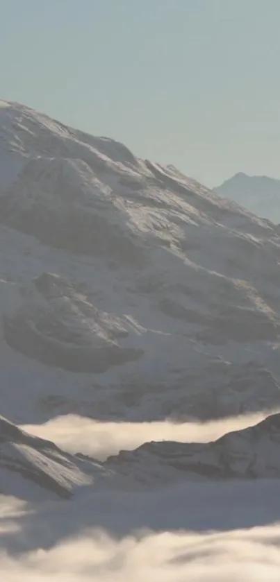 Peaceful snowy mountain scene with misty clouds and light gray tones.